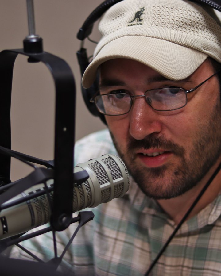 John Luckenbaugh at the microphone, headphones on, running a session.