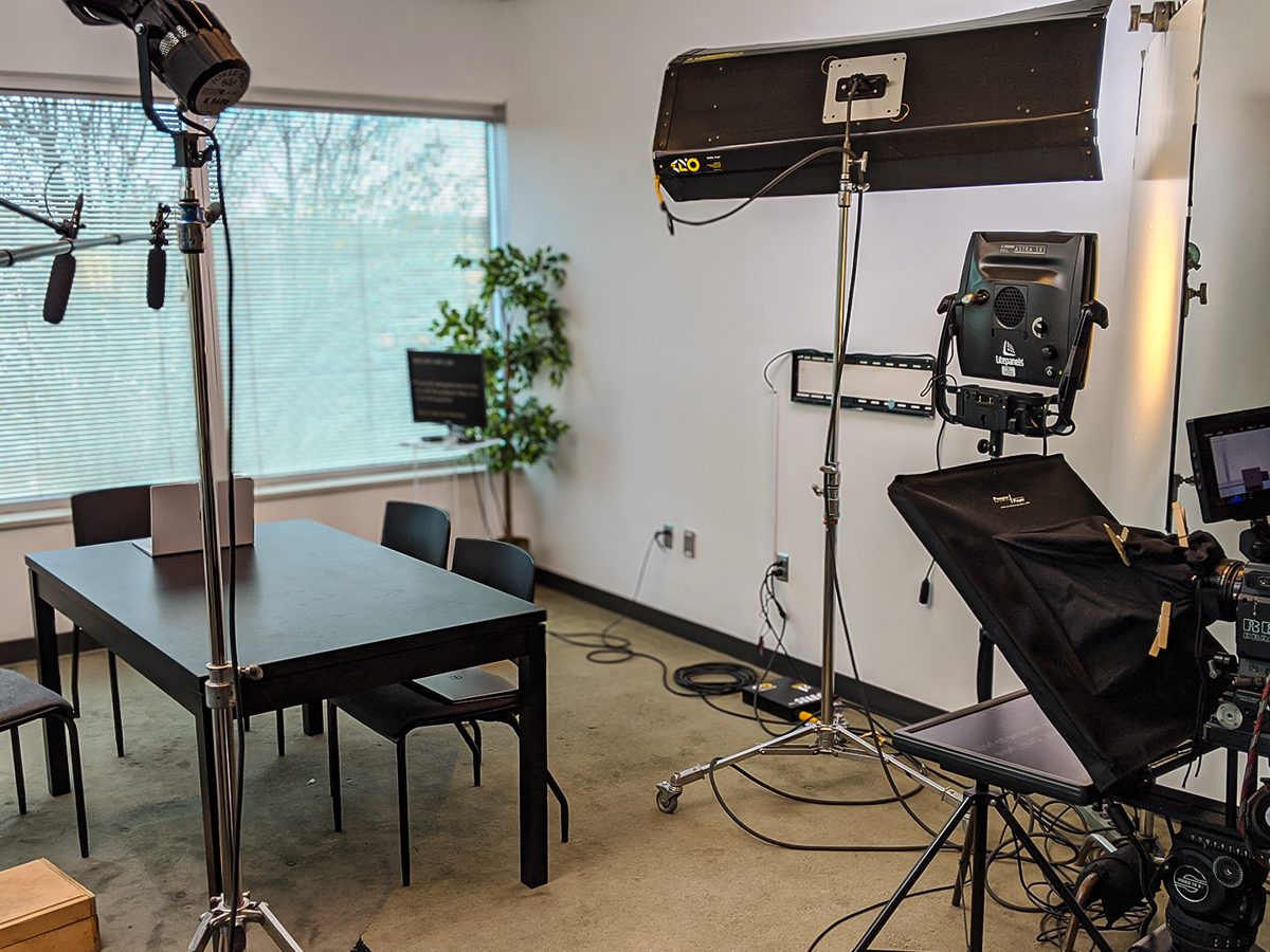 Interview lighting set up beside a flag and a government agency seal.